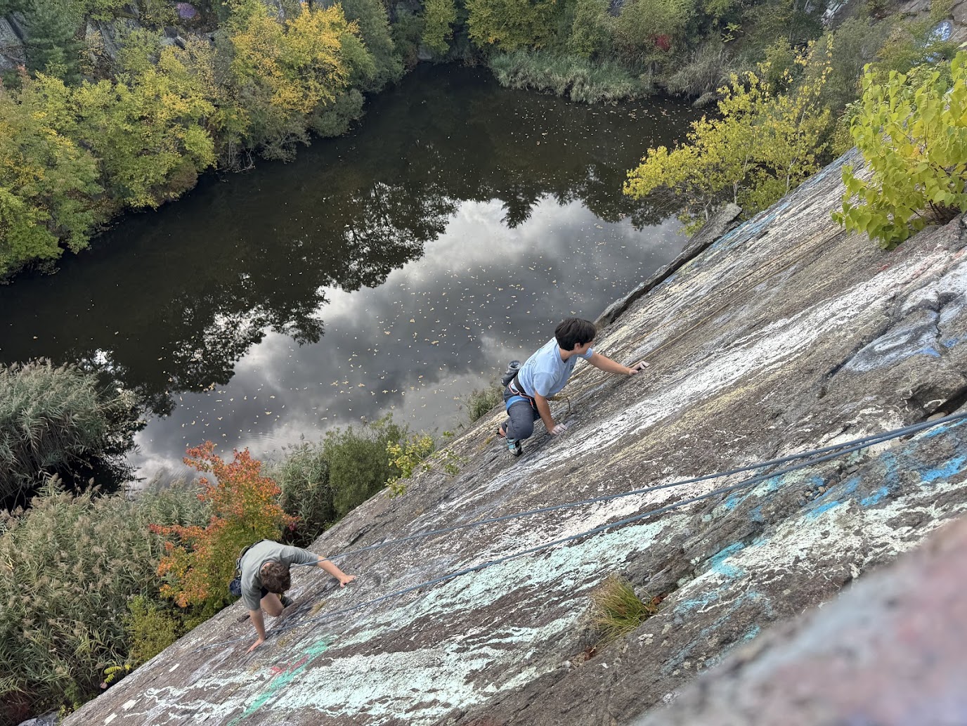 A Northeastern climbing club member being lowered down a 200 foot cliff
